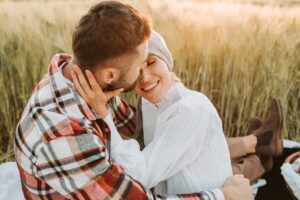 A woman smiles at her partner whilst outside in golden hour