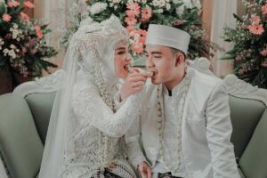 A bride and groom feed each other wedding cake