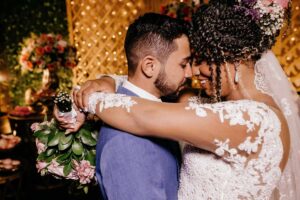 A bride with arms around her new husband showing a proper pose for wedding photos