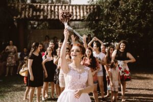 The bridal party posing behind the bride who is about to throw the wedding bouquet