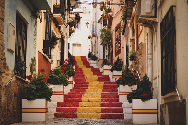 Treppe in einer spanischen Stadt auf der die Spanische Flagge zu sehen ist 