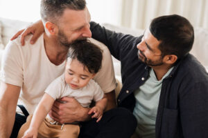 Two dads hold their baby son