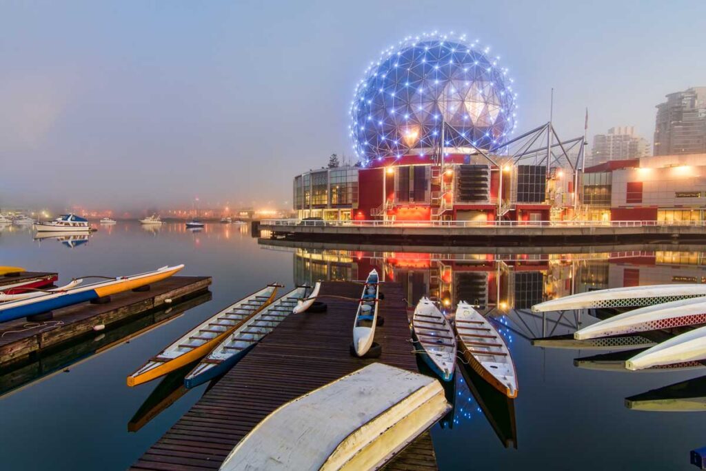 The dome of Vancouver viewed across a body of water dotted with canoes