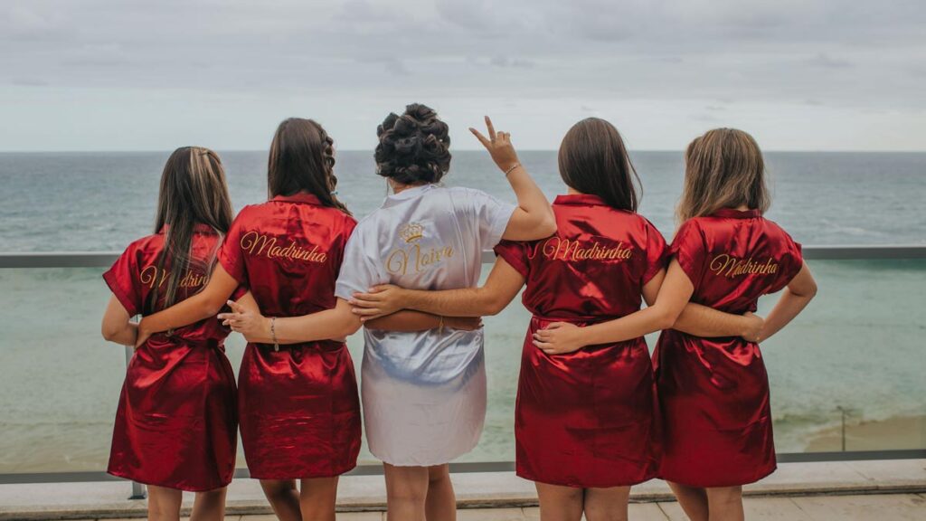 A row of bridemaids standing in front of the sea