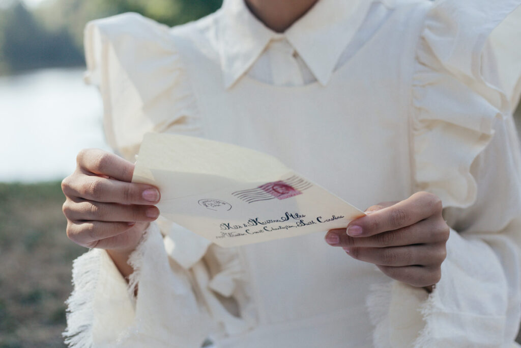 A woman in a white blouse opening a love letter sent as one of the grand gestures to say sorry