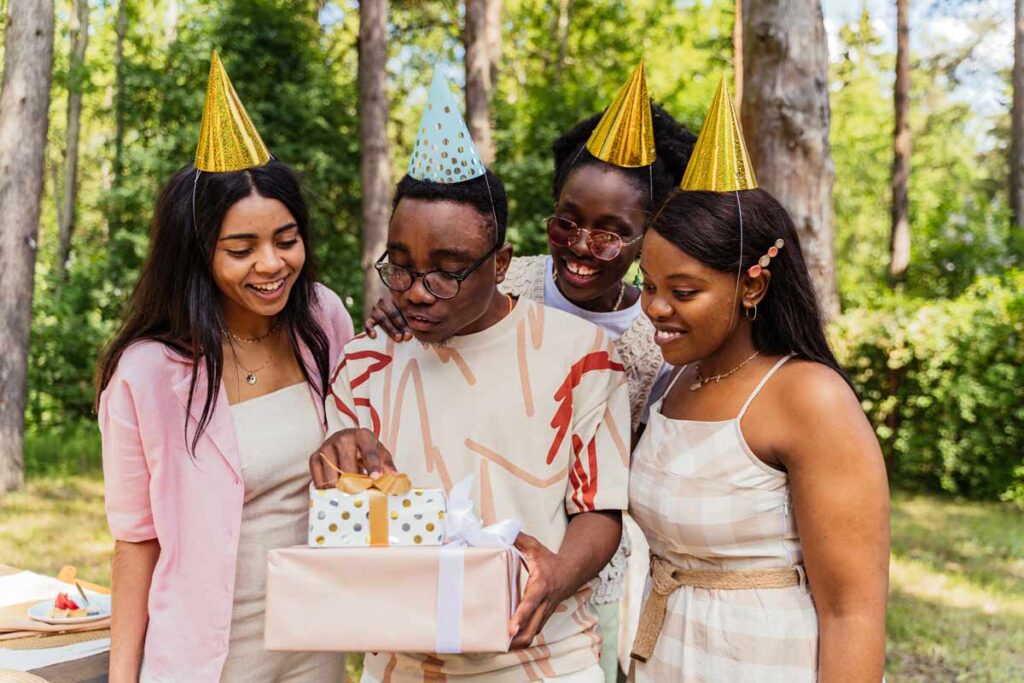 A group celebrate a birthday with gifts