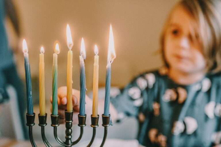 A child lights the candles of a menorah during Hanukkah