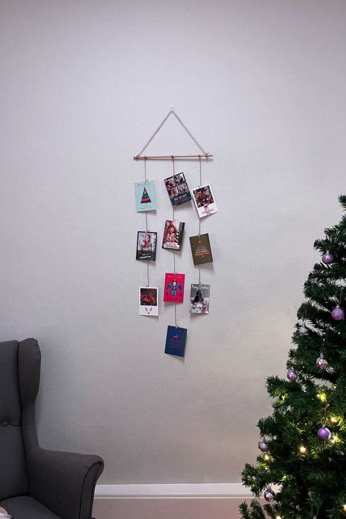 A DIY Christmas mobile with holiday cards hanging from it.