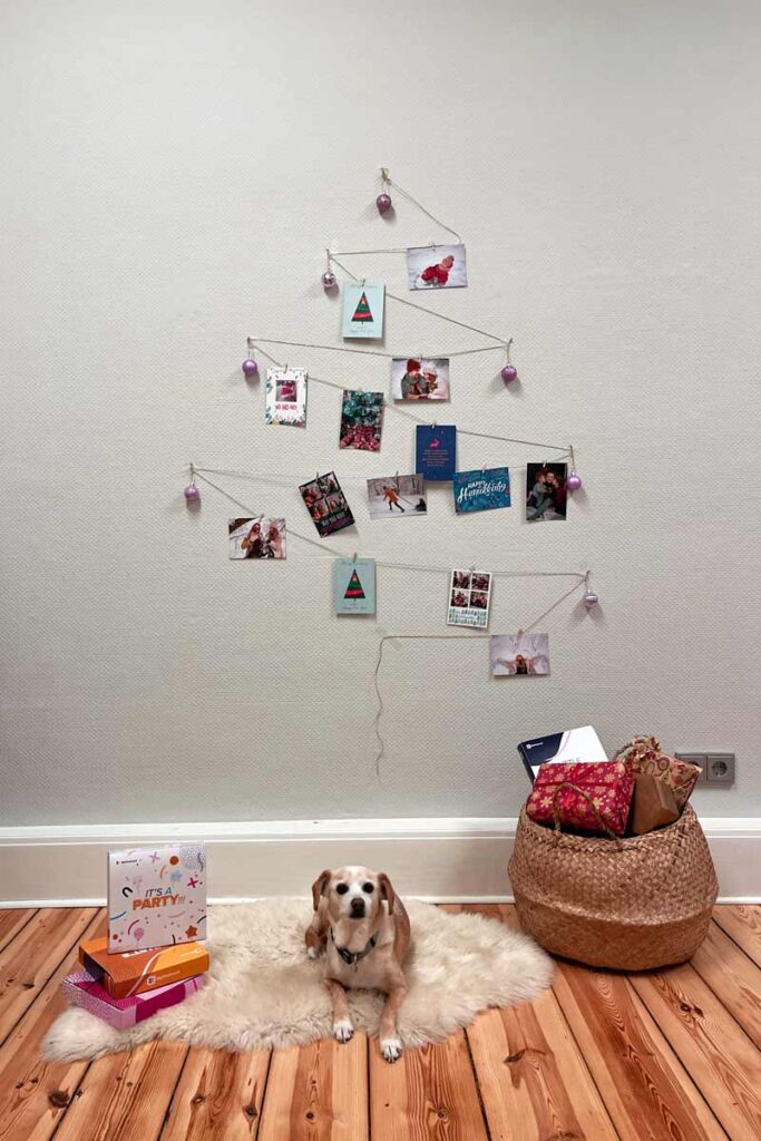 A Christmas tree shape out of string decorated with Christmas cards