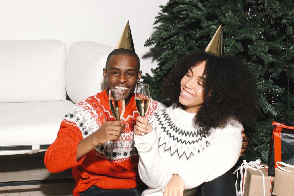 A couple celebrating New Year together next to a Christmas tree