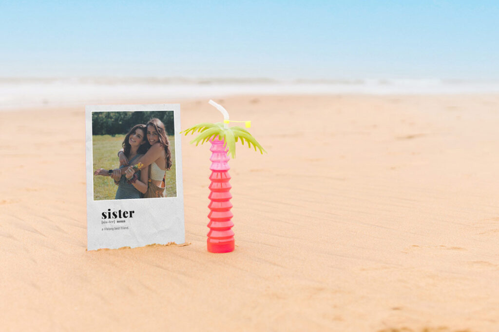 A birthday card for a sister on the beach next to a palm tree souvenir